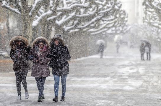 Menschen spazieren durch den starken Schneefall in Nordspanien